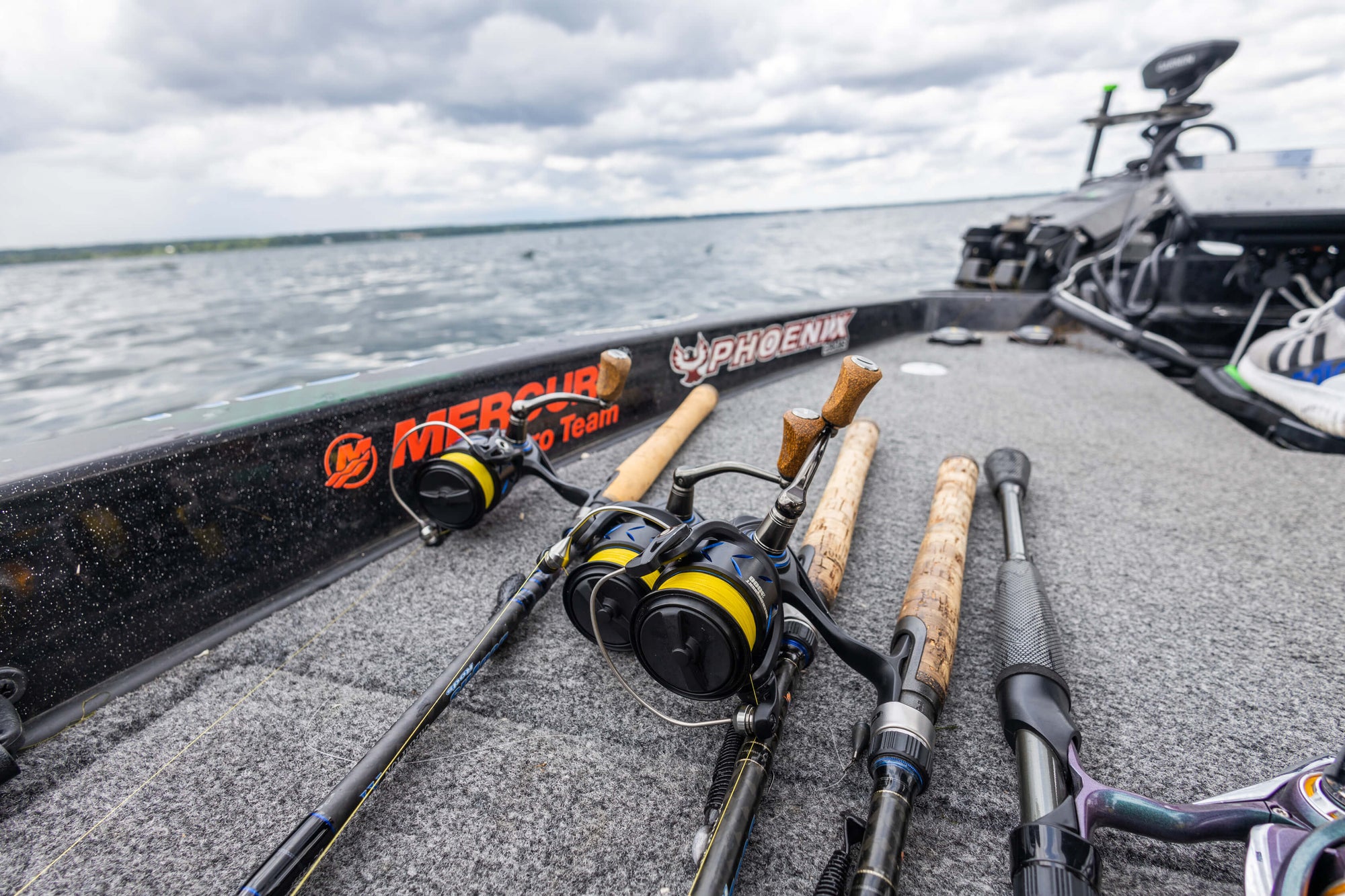Five fishing poles are lying on a boat.