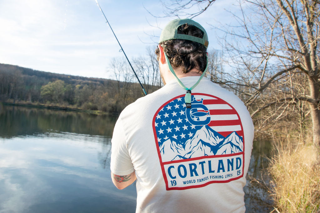 An angler has his back turned to the camera and is fishing