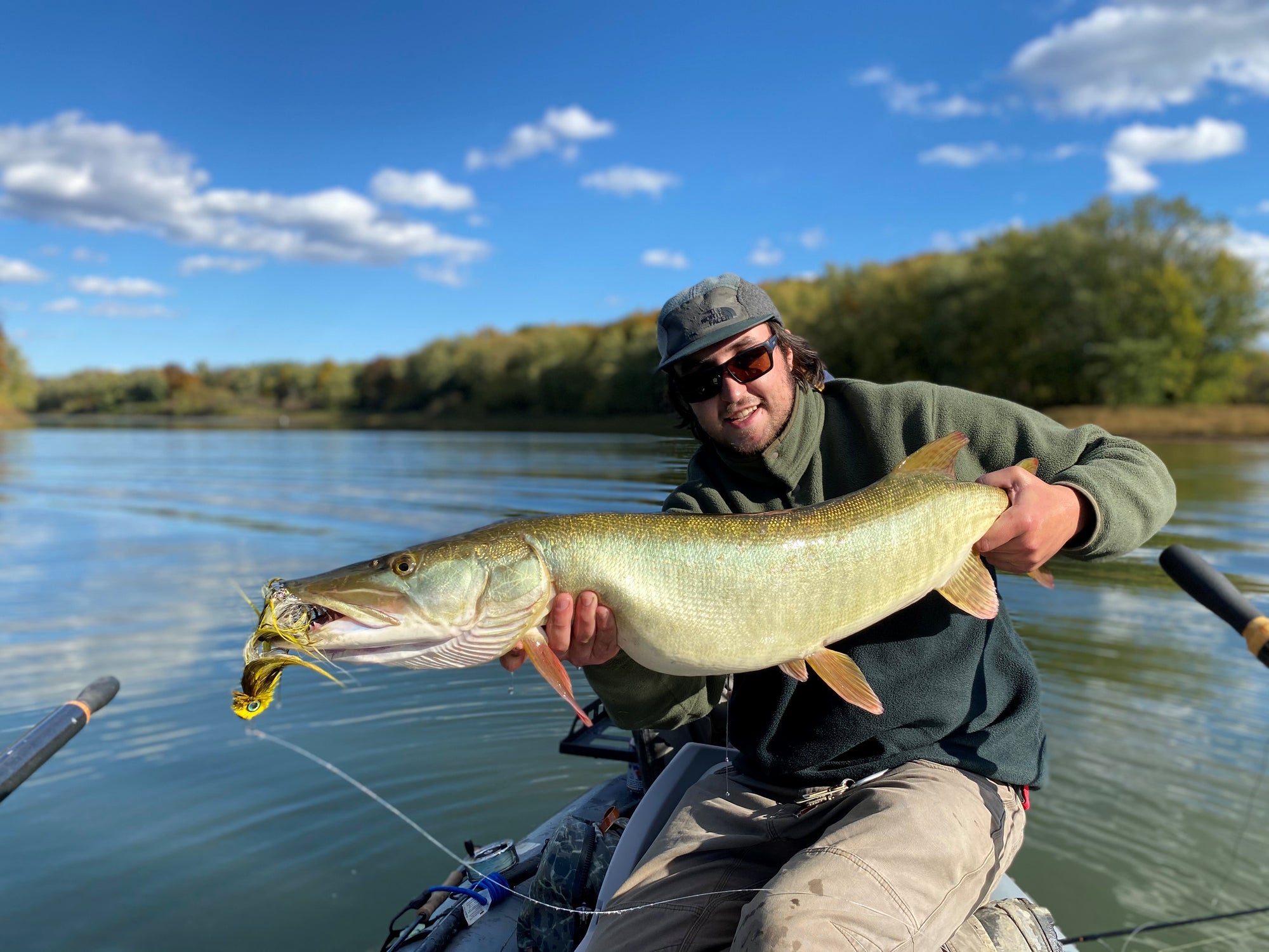 A fisherman is holding up a large fish