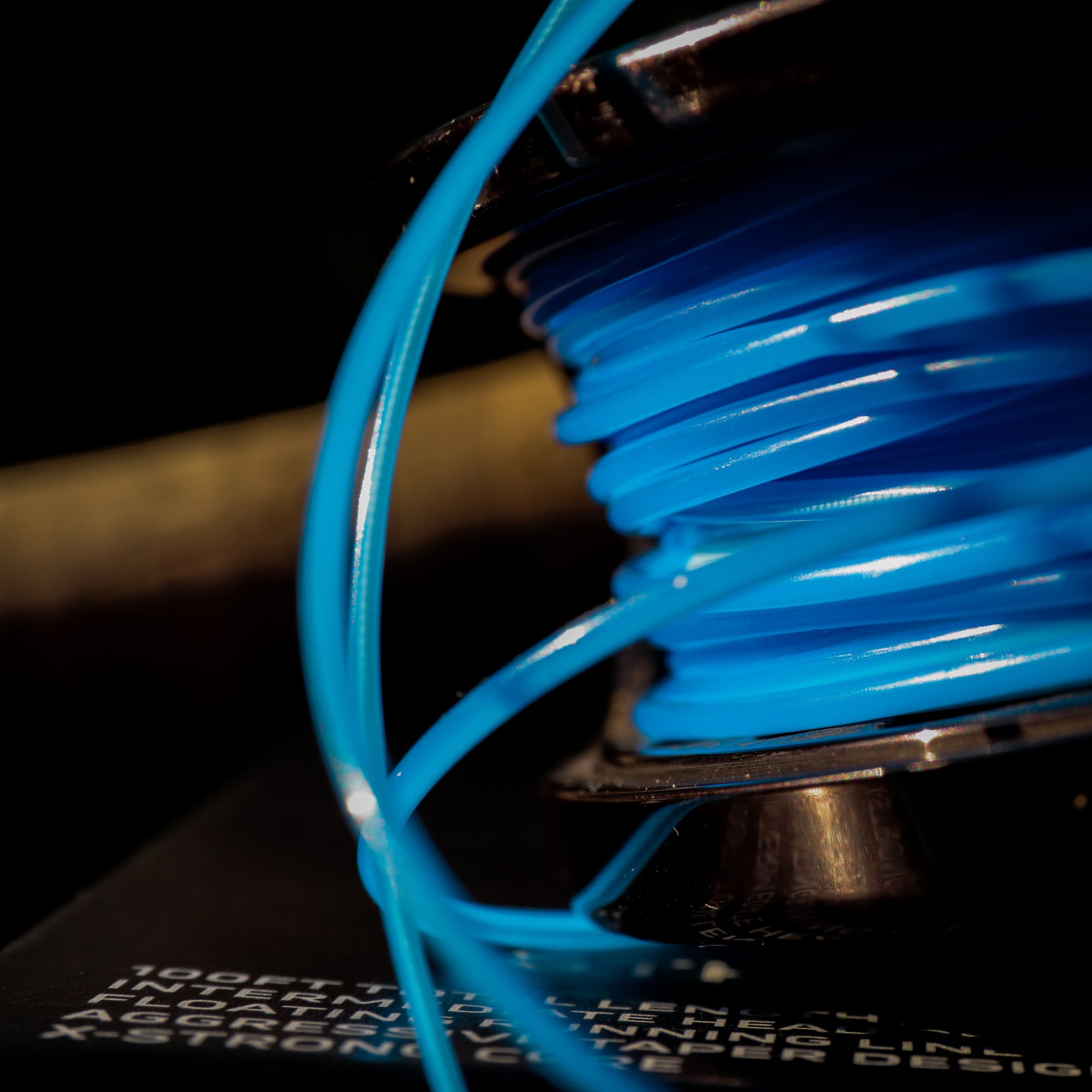 Close-up of a spool of blue line on a dark background