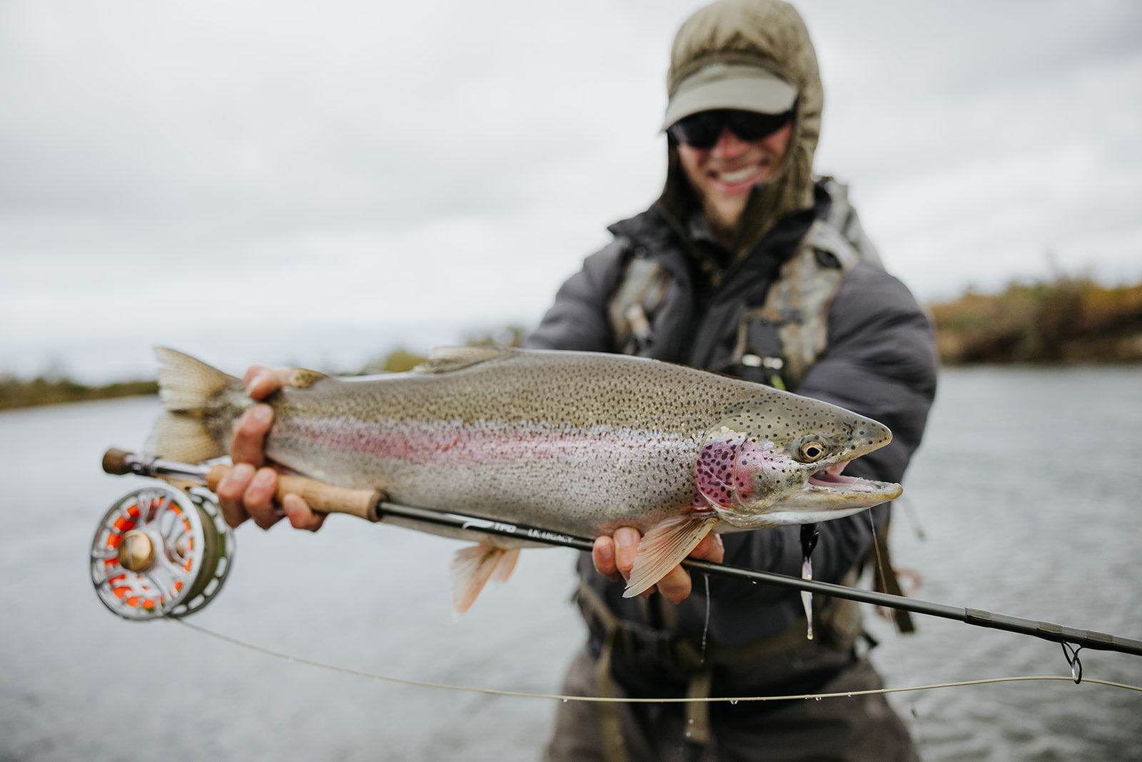 Angler smiling while holding up a trout