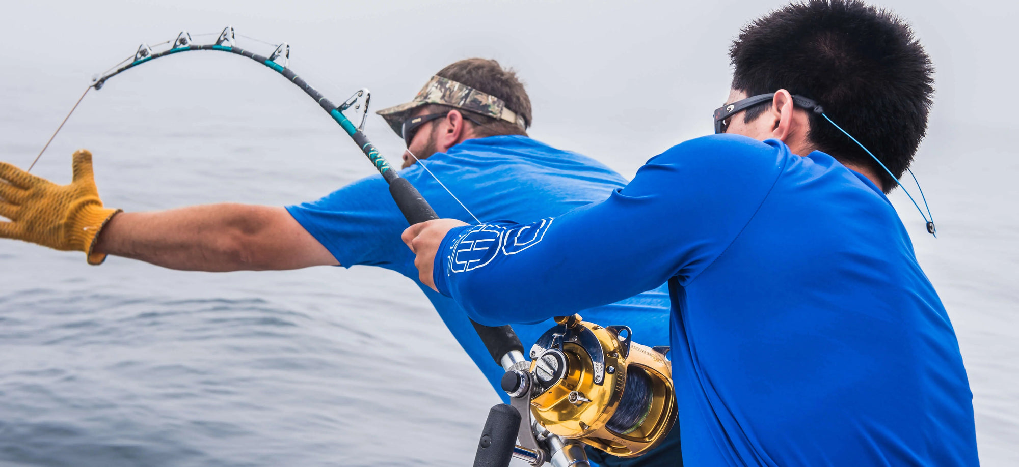 Two people fishing in the water with fishing rods and reels.