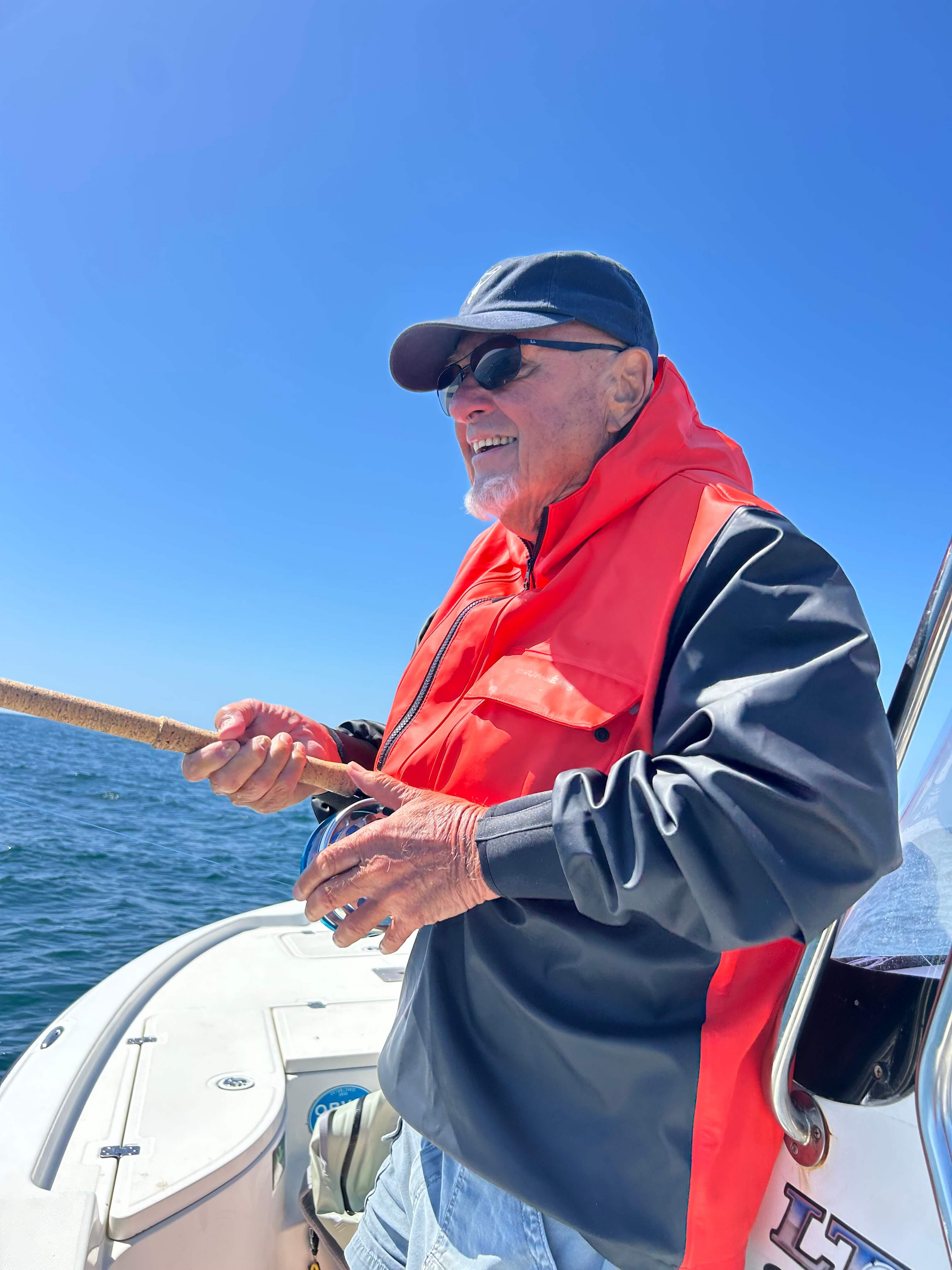 Nick Curcione is back of a boat and holding onto a fly rod. 