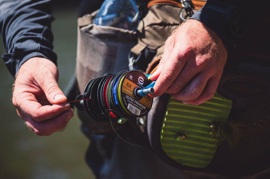 Someone holding onto a variety of spools of Ultra Premium Fluorocarbon Tippet
